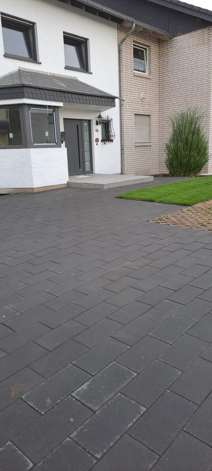 Alee din pavaj lângă o casă cu gazon verde